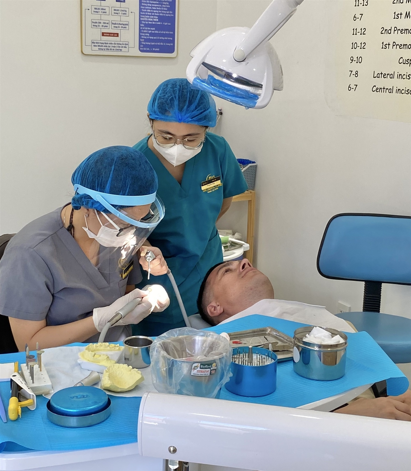 bác sĩ đang gắn răng sứ cho khách hàng nga andrey tại nha khoa ami